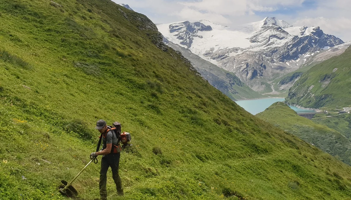 © (DAV Gangkofen) Paul bei der Arbeit, im Hintergrund der Stausee mit Staumauer