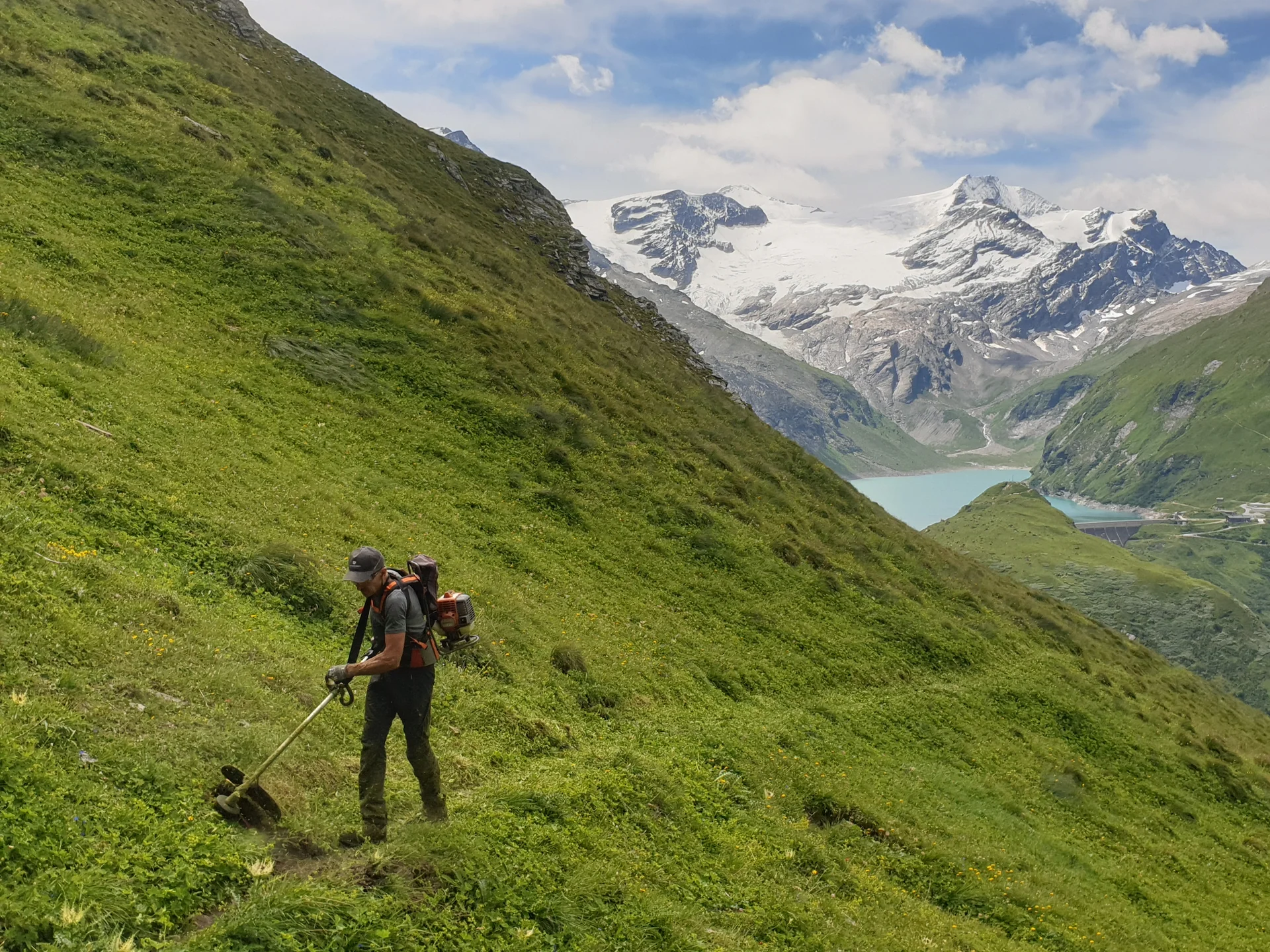 © (DAV Gangkofen) Paul bei der Arbeit, im Hintergrund der Stausee mit Staumauer